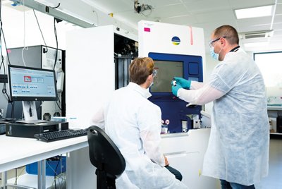 Two man in a lab using Vitek 2 compact