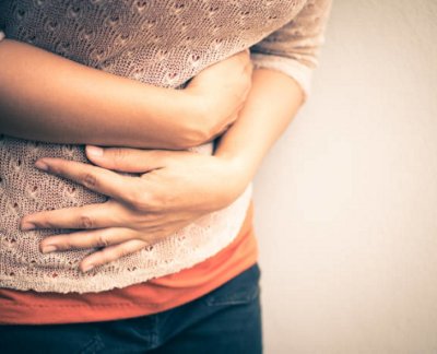 Young beautiful woman having painful stomachache.Chronic gastritis. Abdomen bloating concept.