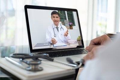 Doctor on video conference or teleconference, dicussing on case study via laptop computer in doctor room. Medical student studying with professor on internet channel. Telemedicine concept