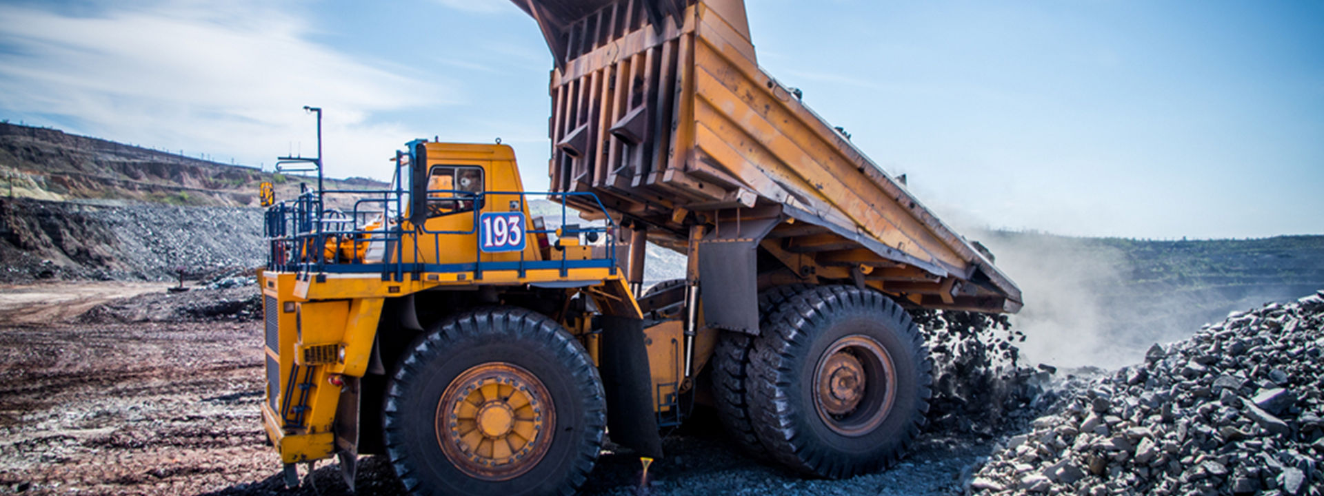 A forklift equipped with Bridgestone off-the-road tyres is moving shipping containers across a large industrial port