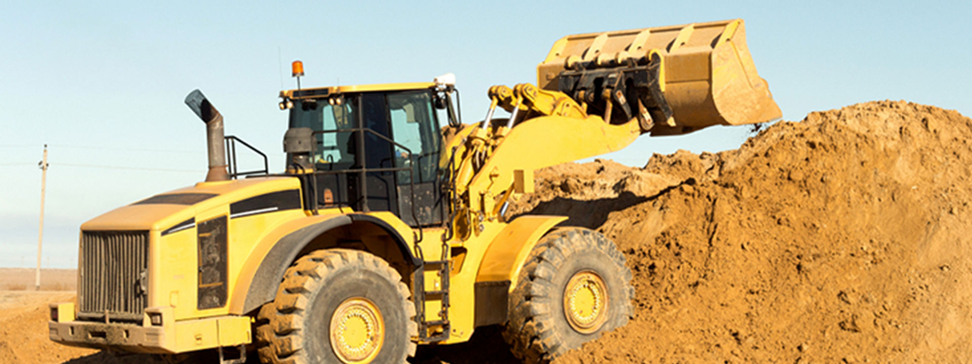 A forklift equipped with Bridgestone off-the-road tyres is moving shipping containers across a large industrial port