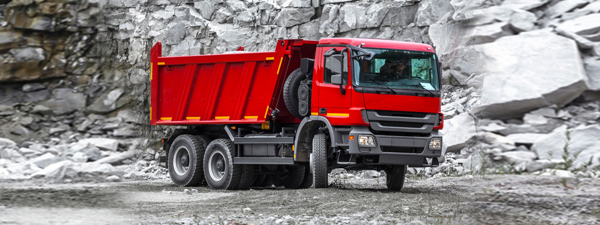 This image shows a long-haul truck driving on a regional road with Bridgestone versatile truck tyres.