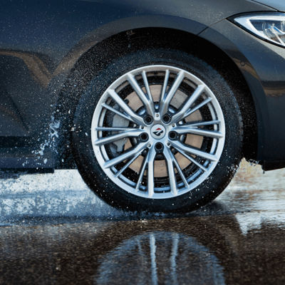 Uma perspetiva lateral dinâmica de um pneu Turanza a salpicar água.