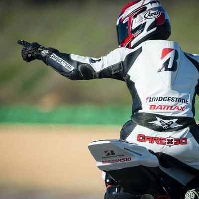 This image shows a back view of a motorcyclist riding with Bridgestone race tyres