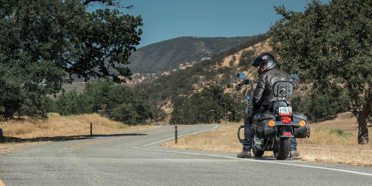 This image shows a back view of a motorcyclist using Bridgestone custom motorcycle tyres