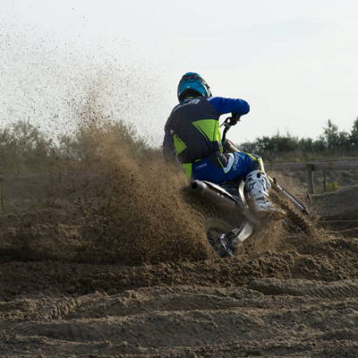 This image shows a back view of a rider on a motorcycle with Bridgestone off road tyres