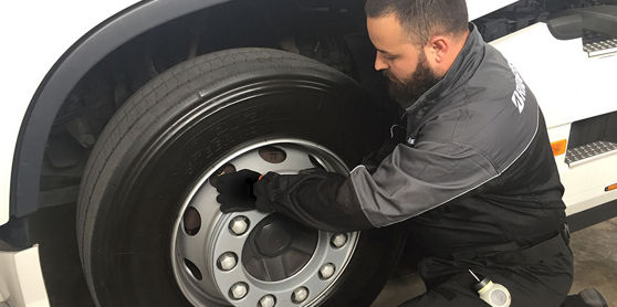 Esta imagen muestra a un operario de Bridgestone instalando Tirematics en un neumático de una flota.