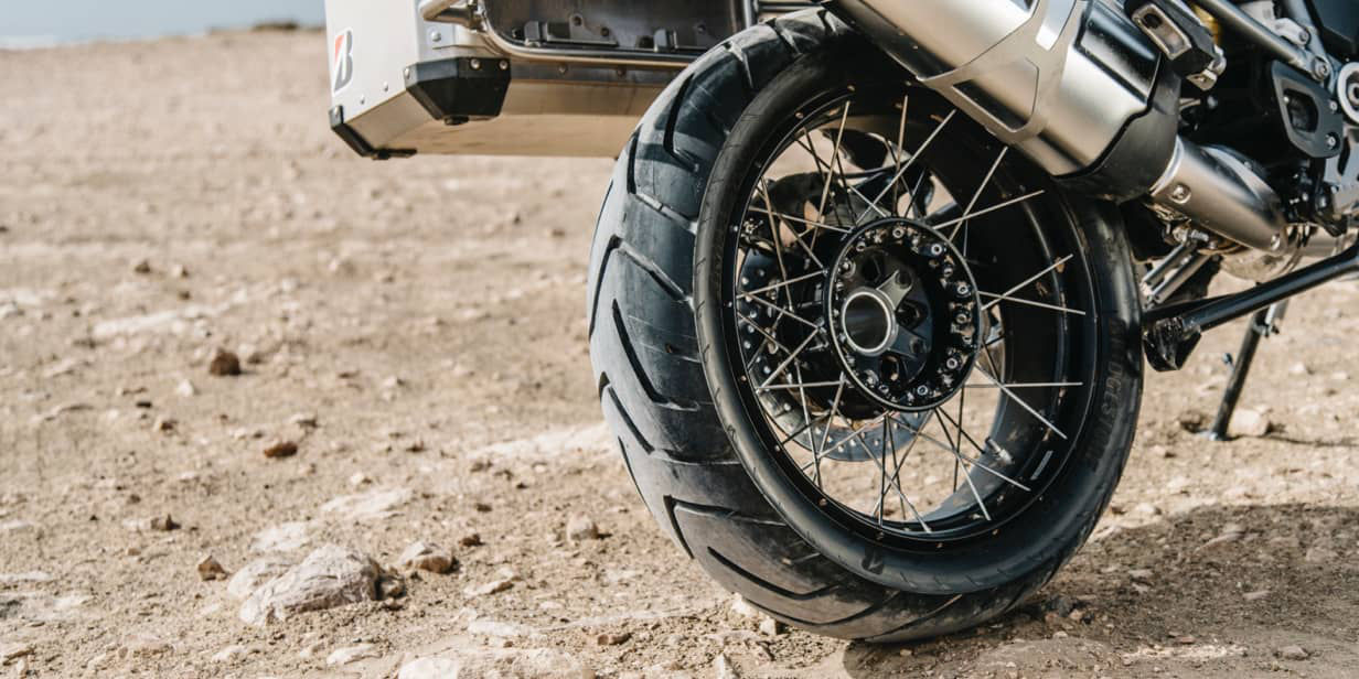 This image shows a close-up of a Bridgestone adventure tyre on a motorbike