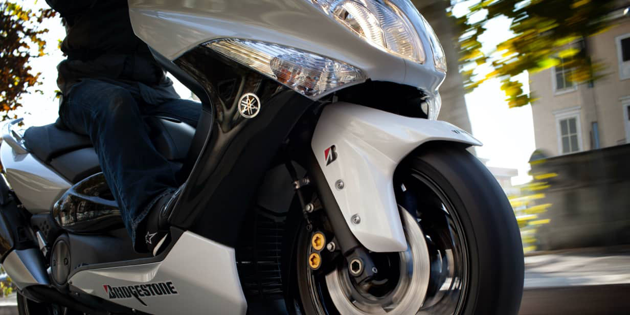 This image shows a close-up of a Bridgestone tyre on a scooter