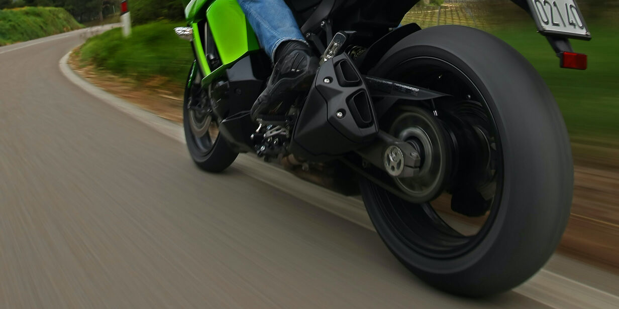 Na tej sliki je prikazan bližji posnetek delovanja pnevmatike Bridgestone, ki obvladujejo motocikel pri vožnji v ovinek. 