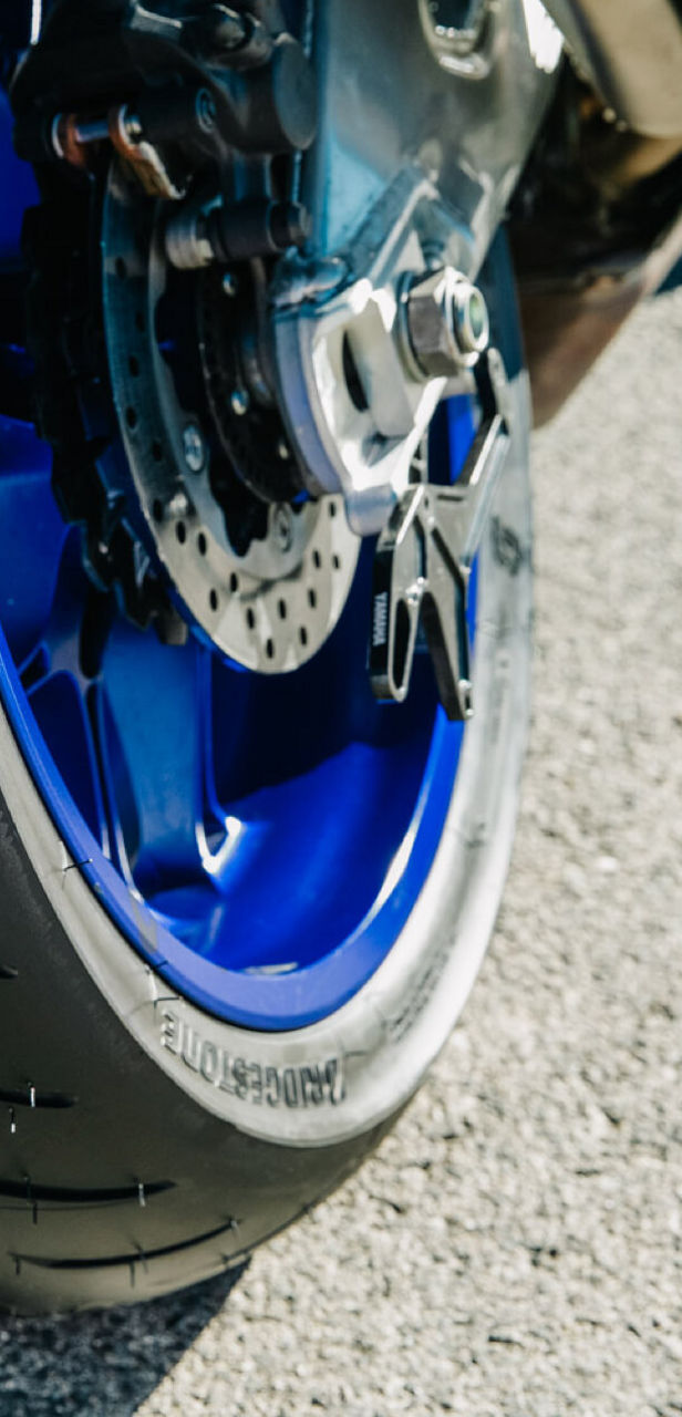 Na tej fotografiji je prikazan bližinski posnetek Bridgestonove zadnje pnevmatike na športnem motociklu.