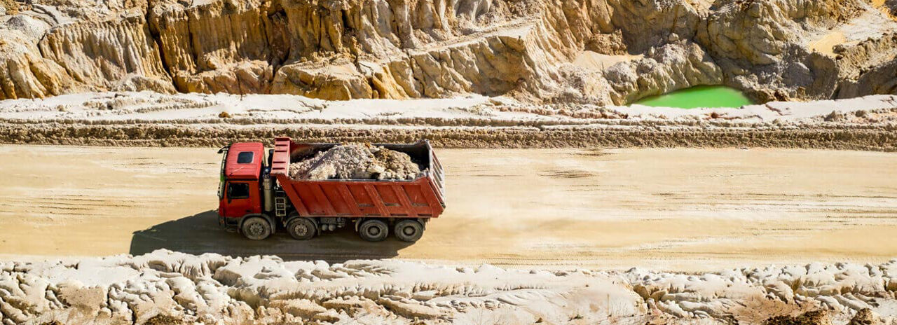 Kuvassa on Bridgestonen vaativaan maantie-maastoajoon tarkoitettuja renkaita käyttävä kuorma-auto heikkokuntoisella hiekkatiellä.