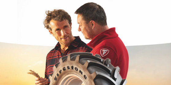 Ein Bauer und ein Firestone Außendienstmitarbeiter besprechen Firestone AG Reifen