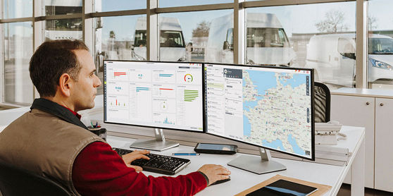 Webfleet -Bilden visar en vagnparkschef som sitter vid skrivbordet och arbetar med data för Webfleet-lösningar.