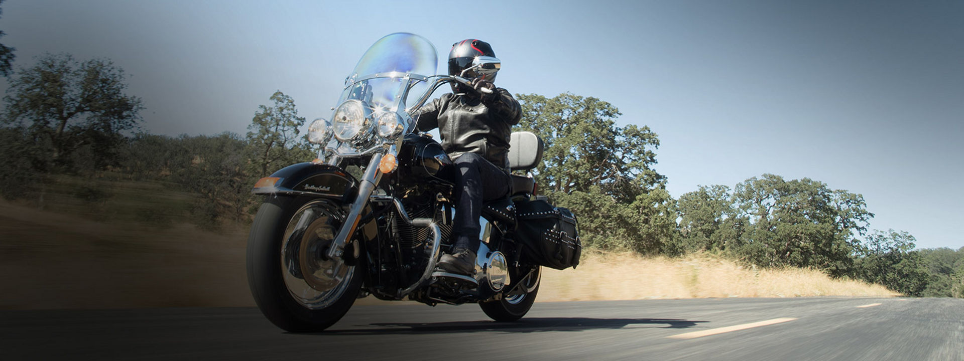 Bilden visar en motorcyklist körandes en Custom-motorcykel utrustad med Bridgestonedäck.