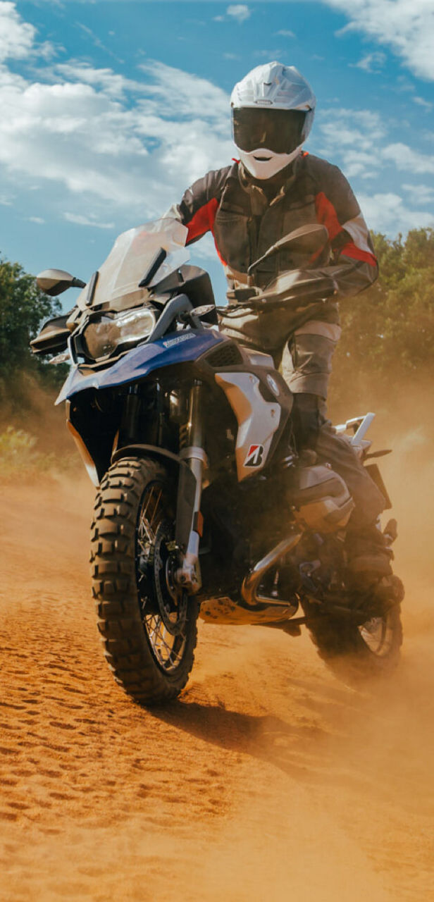 A picture of adventure with a motorcyclist in the sand and his Bridgestone Battlax Adventurecross tyres totally up to it.