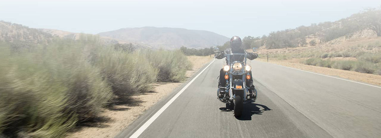 Cette image montre un motard roulant avec des pneus de moto Custom Bridgestone.
