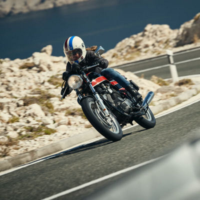 Šioje nuotraukoje matome motociklininką, kuris su „Bridgestone Battlax BT-45“ padangomis rieda gražaus kraštovaizdžio posūkiais.