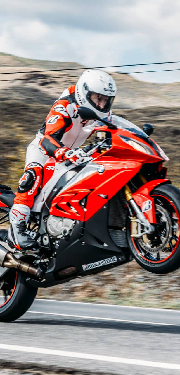 This image shows a motorcyclist with Bridgestone sport tyres performing a wheelie