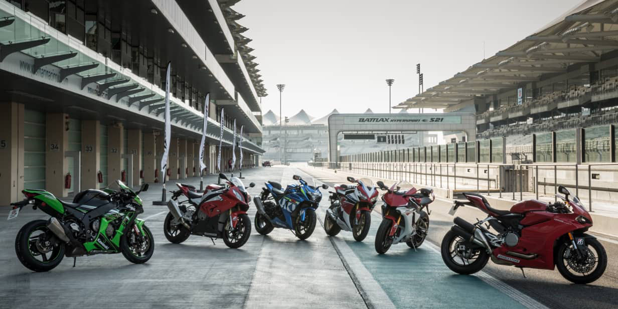 This image shows a range of motorcycles with Bridgestone race tyres near a race track