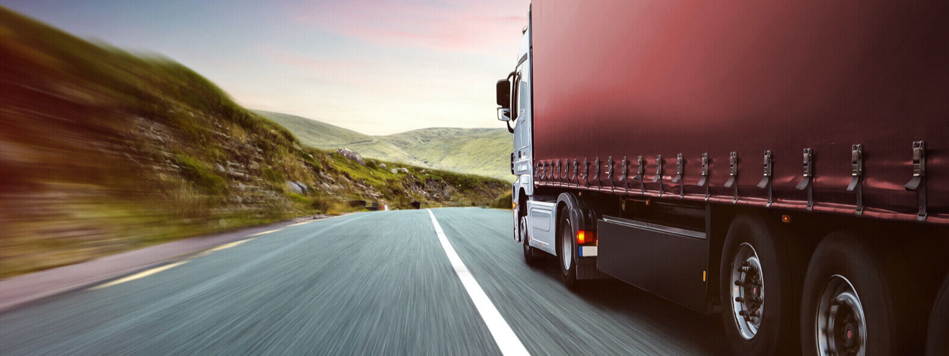 This image shows a side view of a commercial fleet driving on the road with Bridgestone truck tyres.