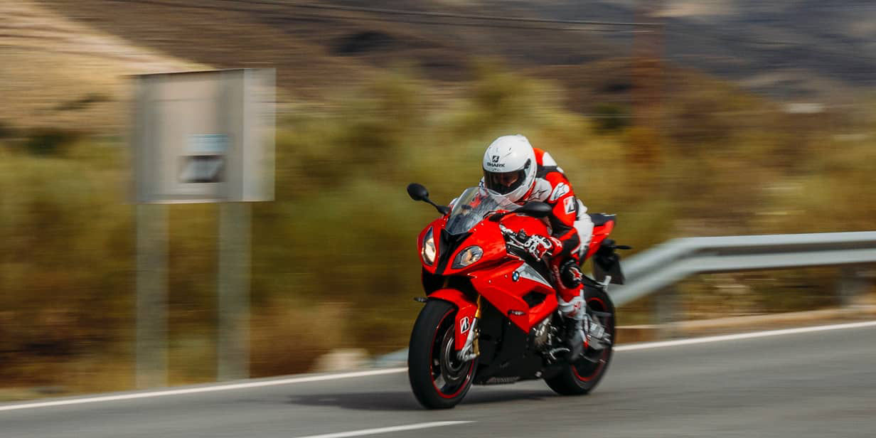 This image shows a side view of a motorcyclist riding at speed with Bridgestone sport tyres