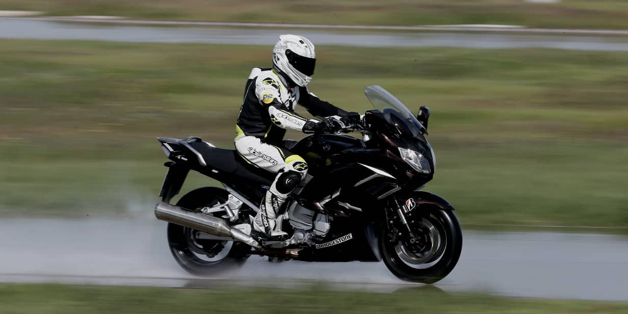 This image shows a side view of a motorcyclist riding with Bridgestone race tyres