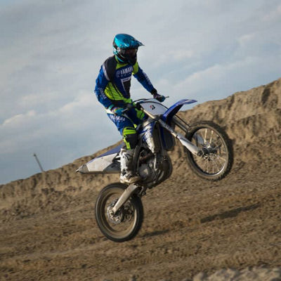 This image shows a side view of a rider wheeling with Bridgestone off road tyres