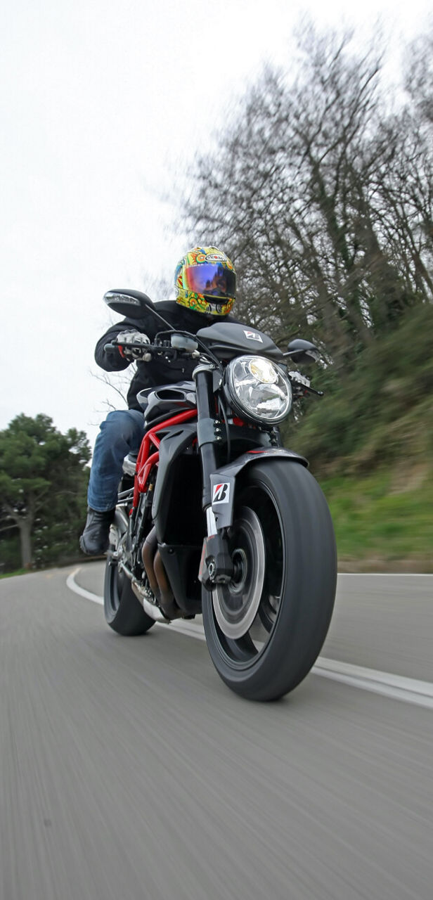 This picture captures a sportive drive of a motorcyclist using his Bridgestone tyres for grip on the road.