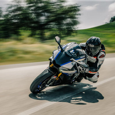 This image shows a sportive motorcycle driver cornering with Bridgestone tyres on a high way.
