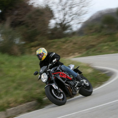 This image shows a sportive motorcyclist cornering with Bridgestone tyres on a windy road.