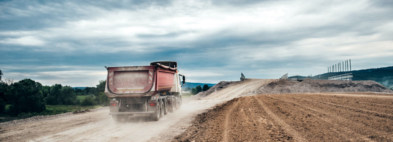 Questa immagine mostra un mezzo con pneumatici cava/cantiere leggero che viaggia su autostrada proveniente da un cantiere