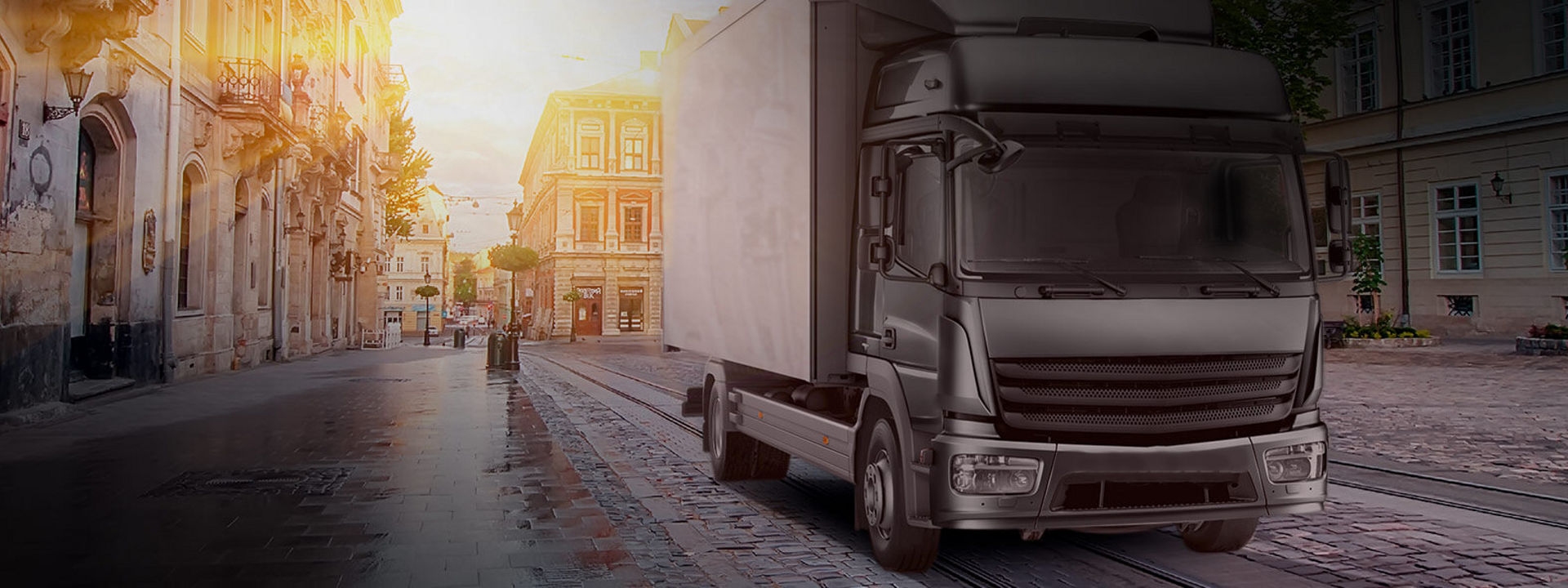 Cette image montre un camion léger/moyen équipé de pneus Bridgestone en route pour livrer des marchandises en centre ville.