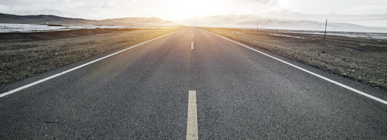 Questa immagine mostra un'autostrada solitaria e panoramica in una regione fredda.