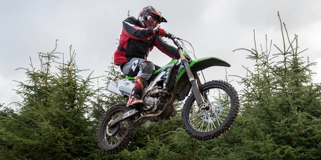This image shows an action shot of a motorcyclist riding with Bridgestone off road tyres