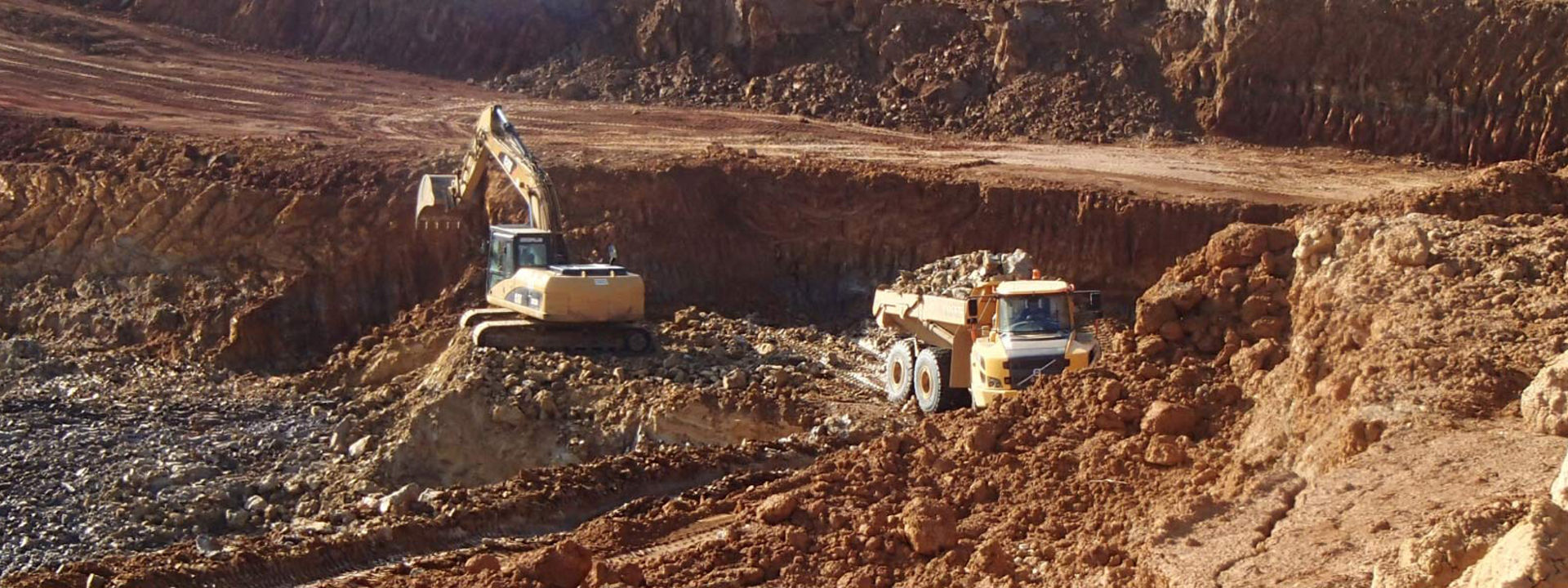 En leddelt dump truck udstyret med Bridgestone terrængående dæk, der arbejder i et stort stenbrud