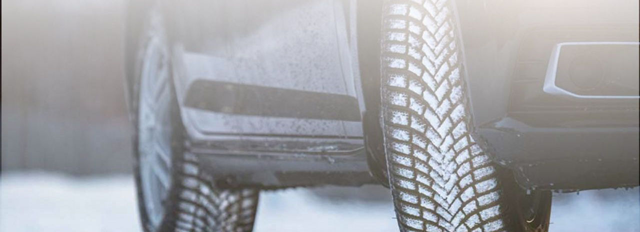 Una imagen en primer plano de un neumáticos de invierno Bridgestone con nieve en el dibujo de la banda de rodadura. 