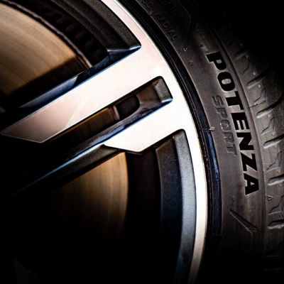 Bližnji posnetek športnega platišča Bridgestone Potenza Sport in napisa na bočni strani pnevmatike. 
