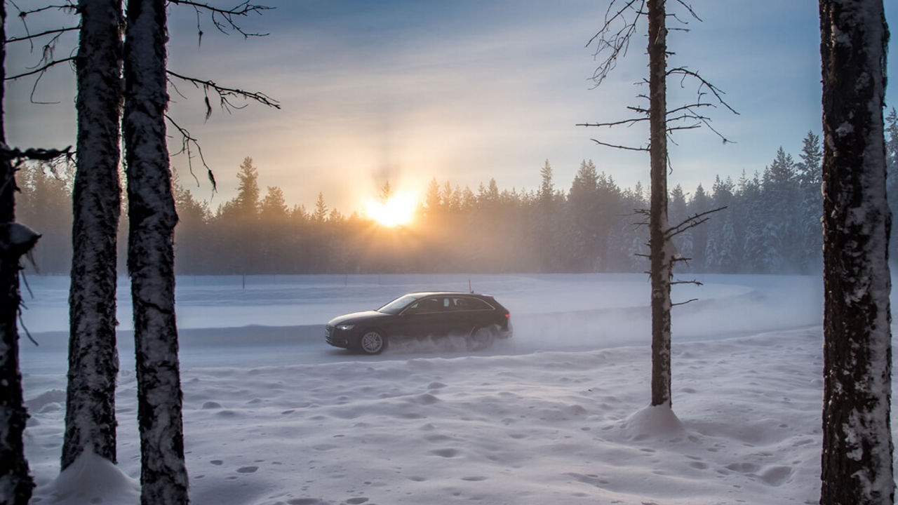 Ein Auto fährt durch eine winterliche Landschaft