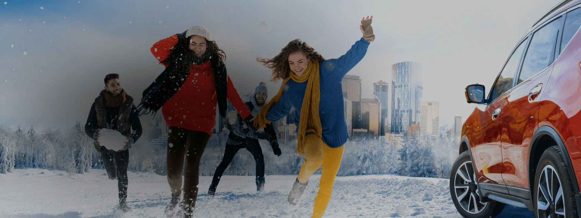 4 friends playing in the snow next to a red car with Firestone tires.