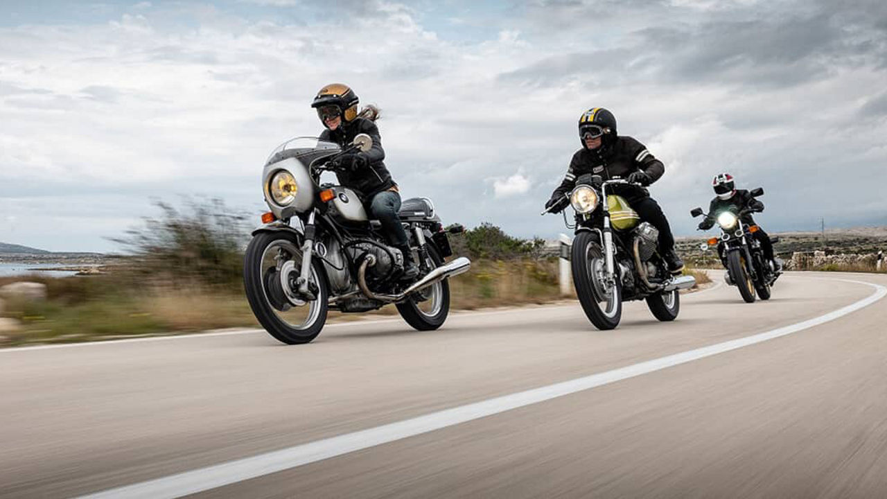 Motorcyclists driving along a mountainous coastline