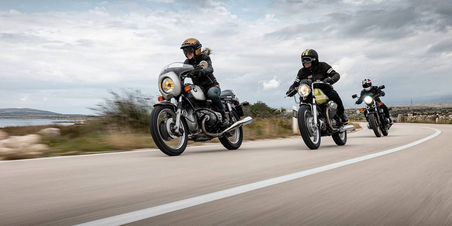 Motorcyclists driving along a mountainous coastline