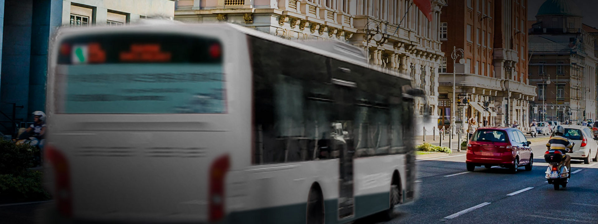 A kép egy városi busz hátulját mutatja Bridgestone városi buszabroncsokkal, amint a városközpontban közlekedik.