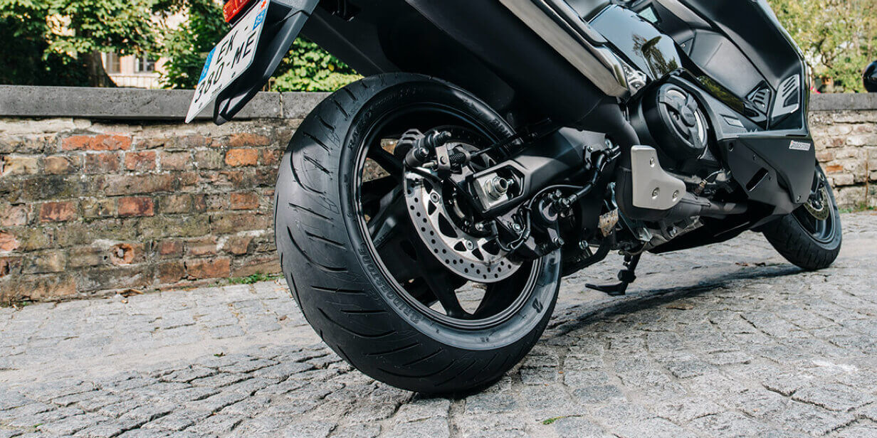 This picture focusses on the Bridgestone Battlax SC-2 tyre at the rear of the sportive scooter.