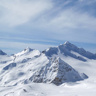 Questa immagine rappresenta un paesaggio invernale della cima di una montagna coperta di neve.