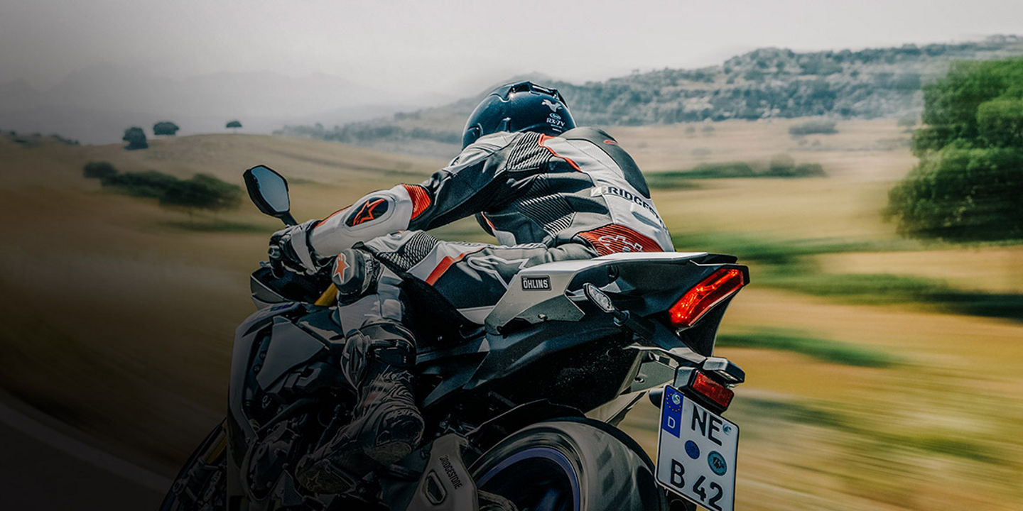 This image shows a motorcyclist riding their motorbike with Bridgestone sport tyres on a road. 