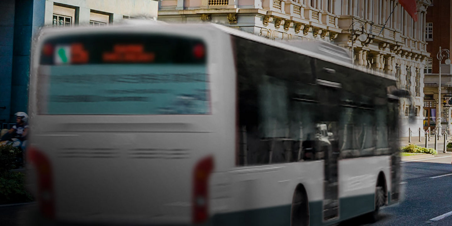 This image shows the back of an urban bus with Bridgestone urban bus tyres driving in the city centre.