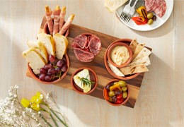 Grazing platter with deli meat, Italian breads, olives and a selection of dips.