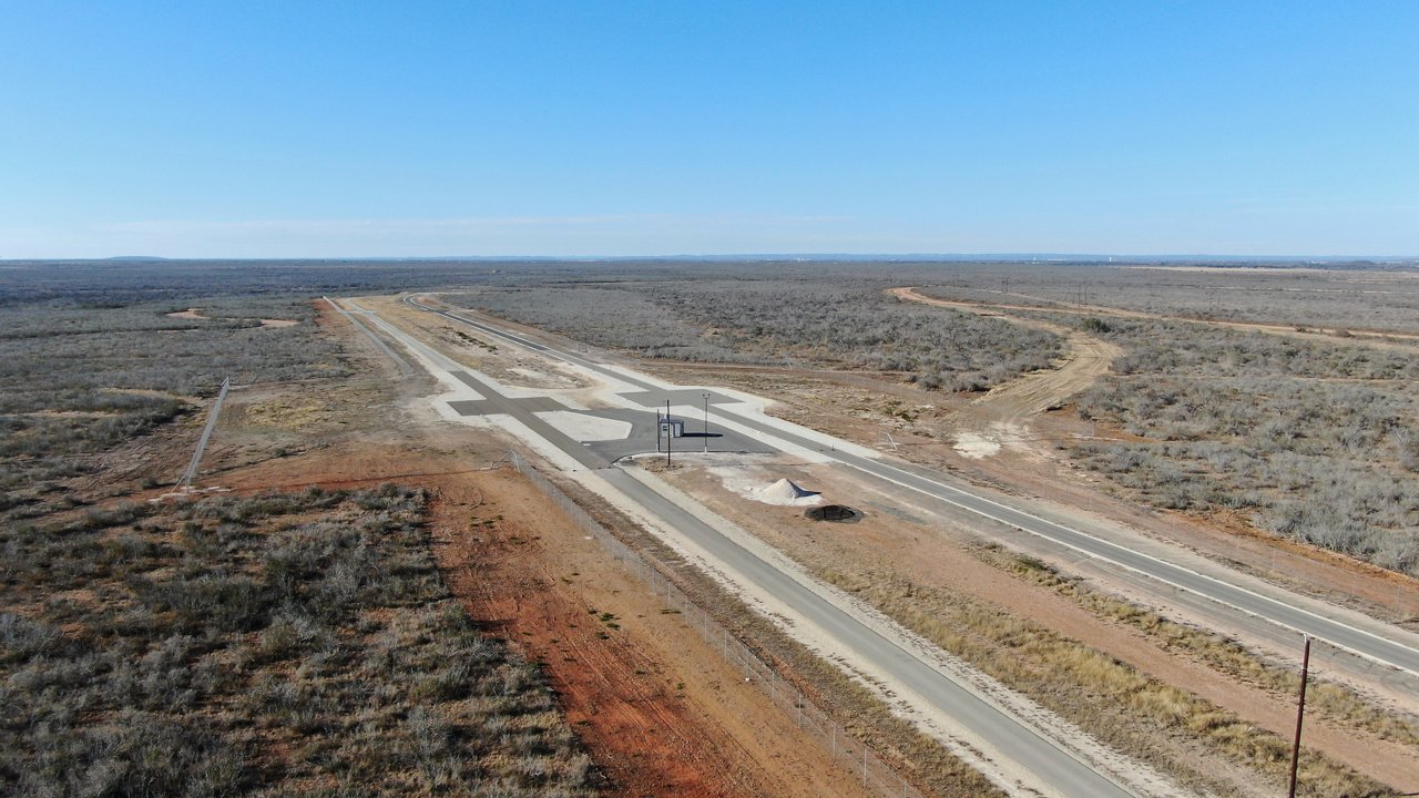 A panoramic view of one of the testing tracks nestled in the expansive desert showcasing a diverse array of surfaces for comprehensive vehicle testing.