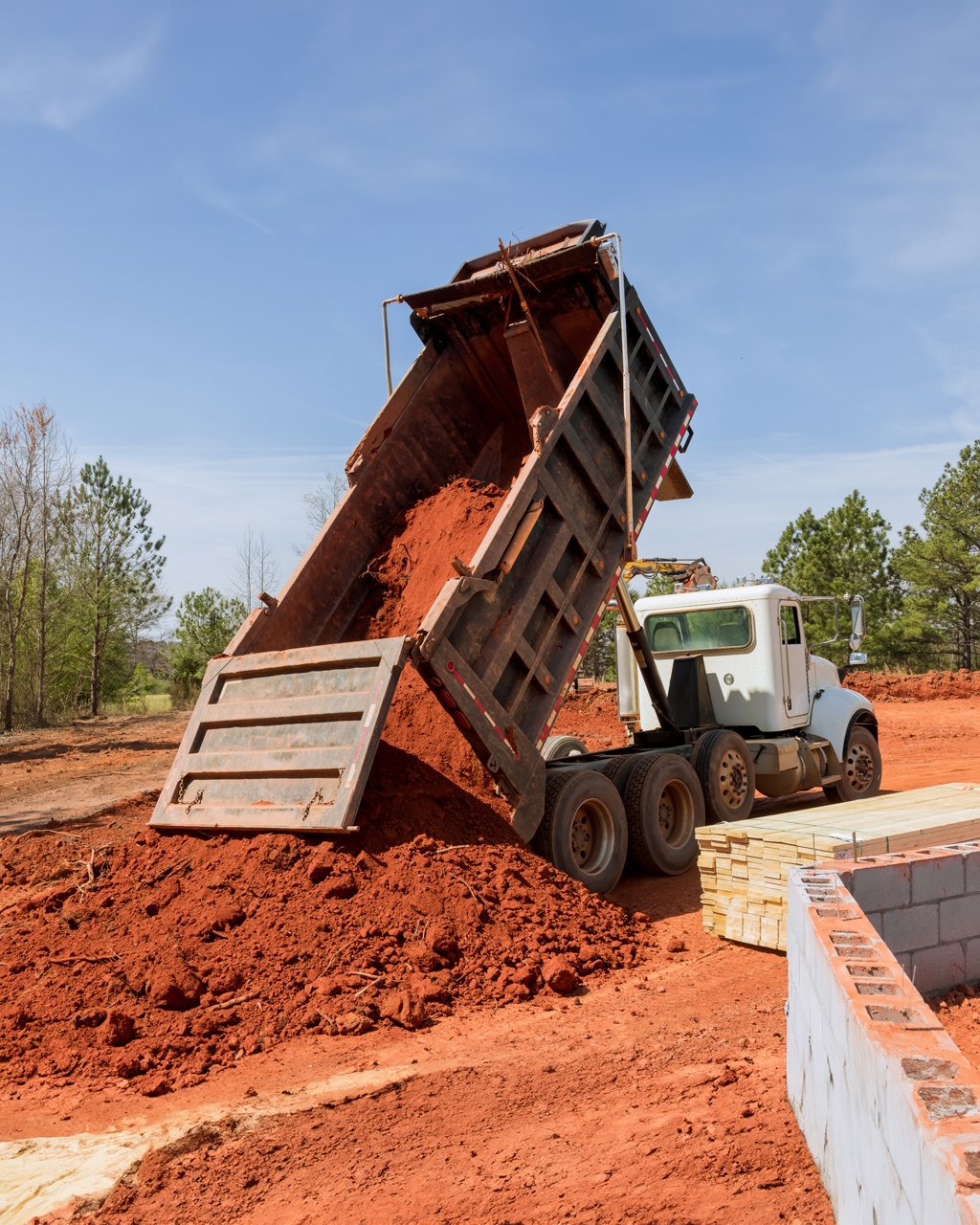 Dump truck dropping of a load of dirt at a construction site